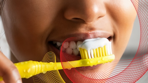 Person brushing teeth with yellow toothbrush
