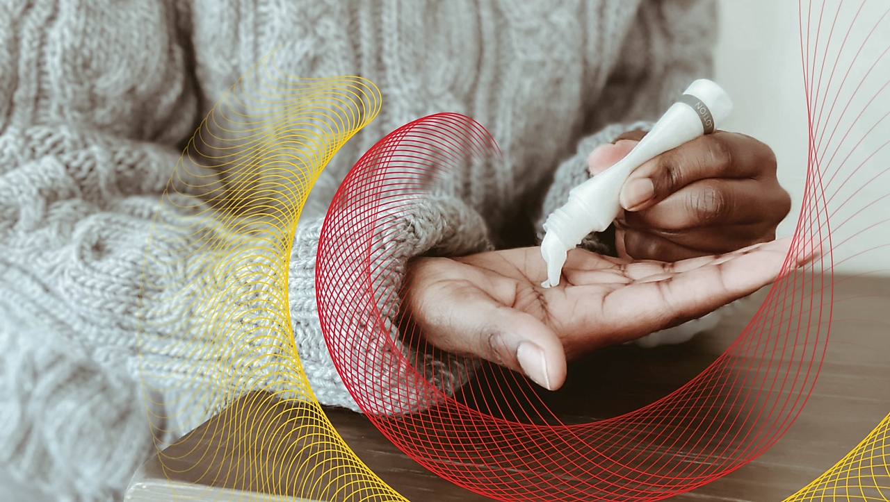 Closeup of person squeezing lotion from tube into palm of hand