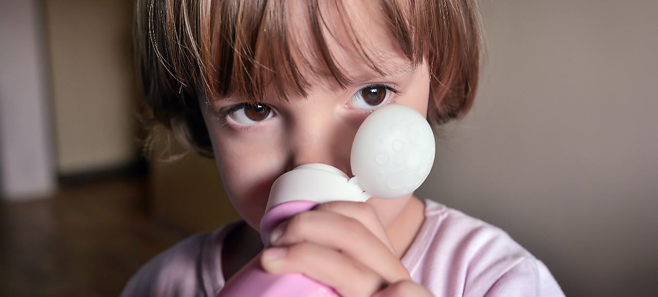 Child sniffing shampoo bottle
