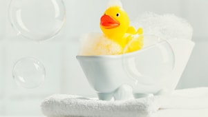 A rubber ducky in a small, soap filled tub