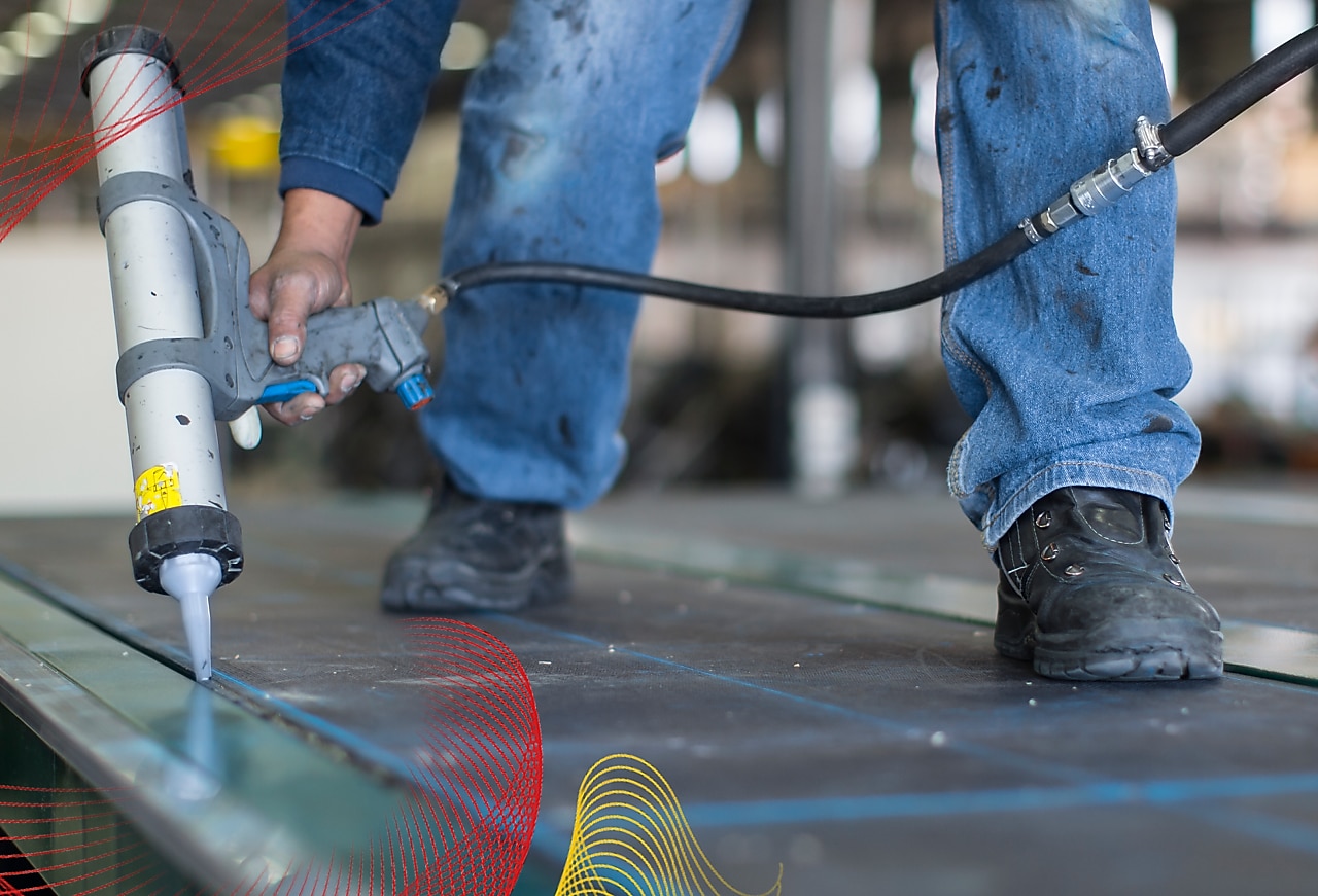 person applying adhesive onto a large industrial surface