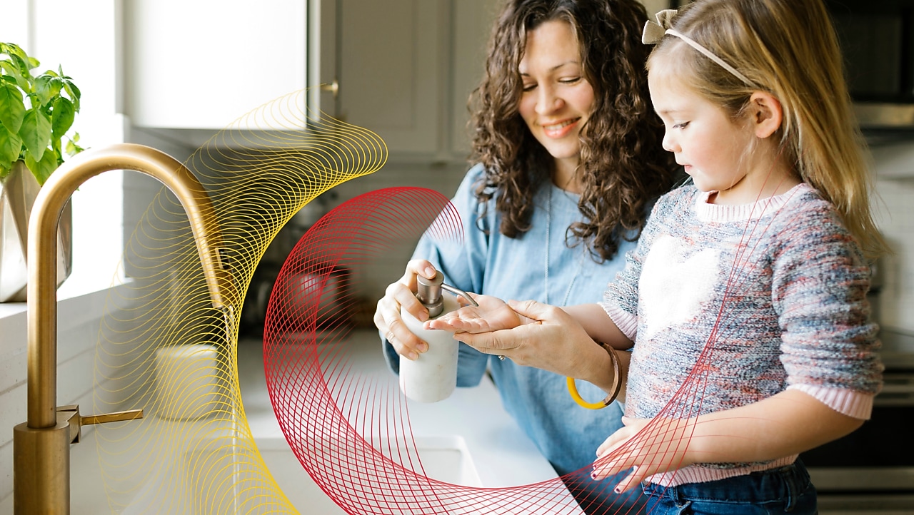 Mother and daughter wash their hands at kitchen sink