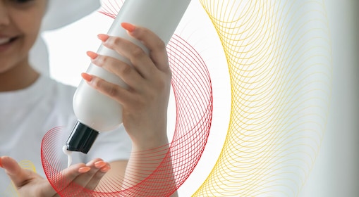 Person squeezing hair care cream into hand