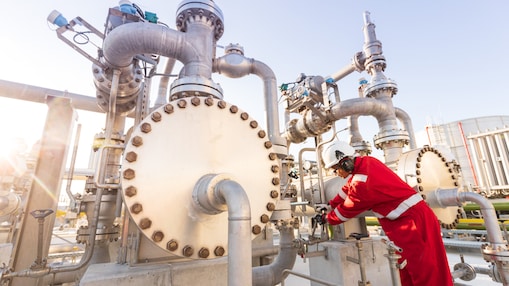 Worker inspecting processing equipment