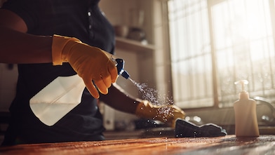 A person spraying to clean the kitchen