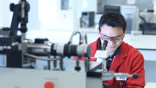 Male researcher studying a microscope