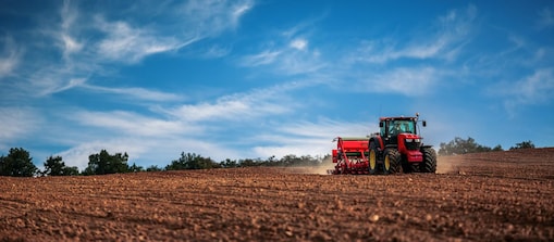 Tractor towing a tilling machine on a field