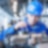 Worker in blue overalls and a helmet working on an engine