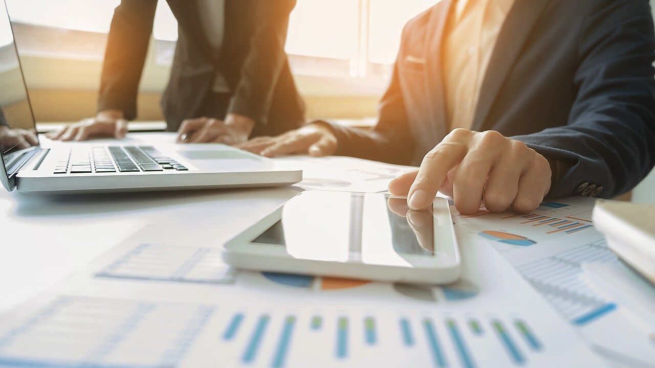 A man touching a touch pad with a laptop in front