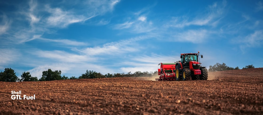 A tractor pulling a seeder drill in a field