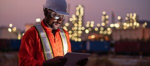 Construction worker in hi-vis reading a tablet