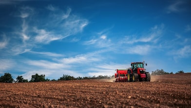 Tractor towing a tilling machine on a field