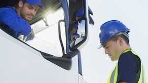 Truck driver talking to a worker out of the truck window