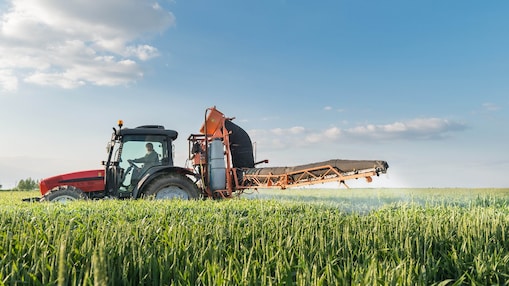 A tractor spraying a crop