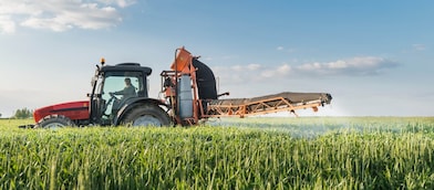 A tractor spraying a crop