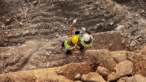 Two workers in a mining operation on a tablet