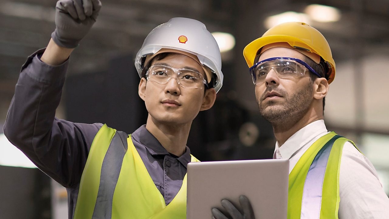 Shell worker consulting an industry worker on site