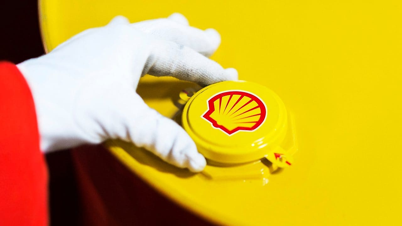 A Shell expert adjusts the lid of a barrel of lubricant displaying the Shell logo