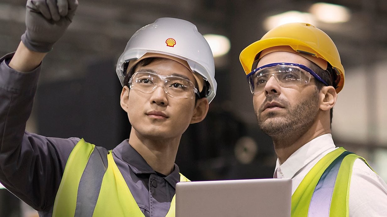 Shell worker consulting an industry worker on site