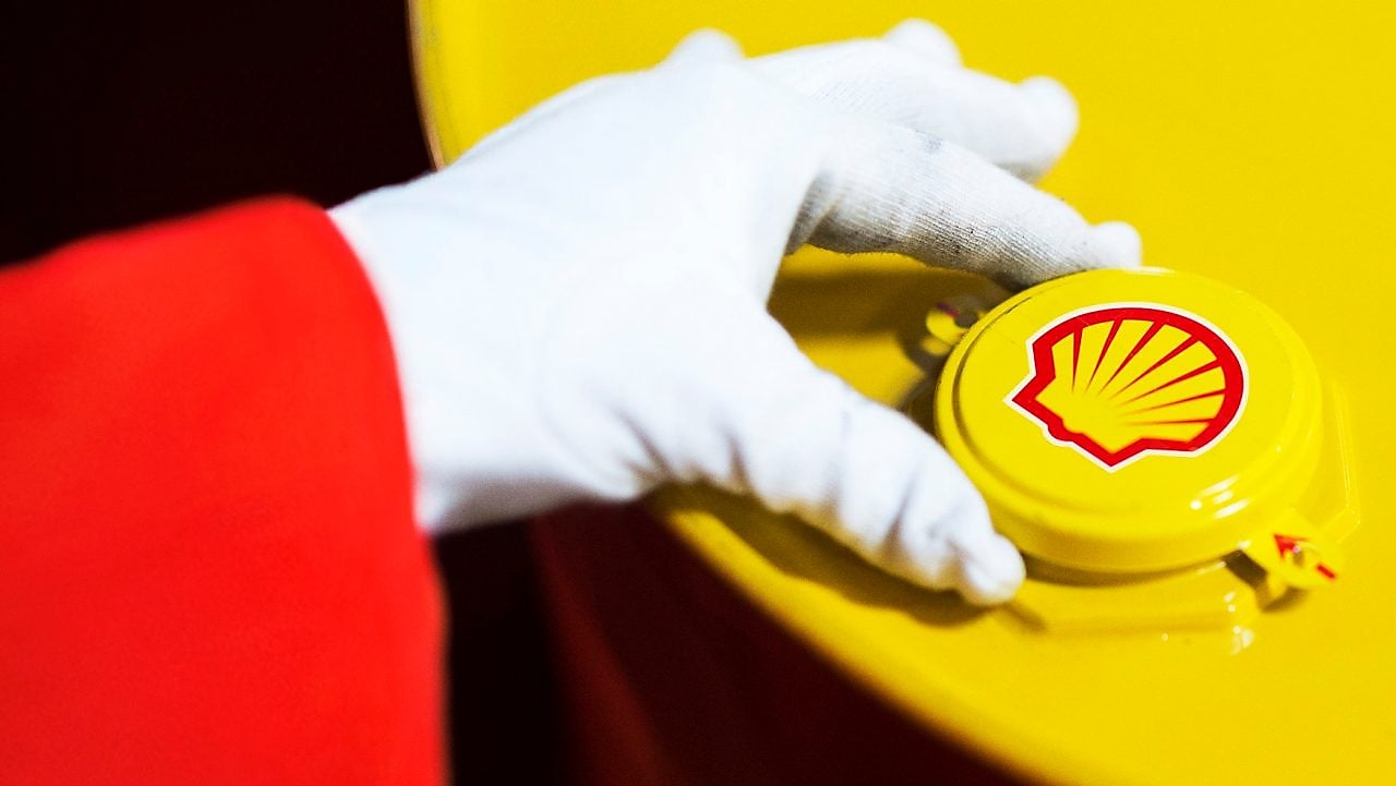 A Shell expert adjusts the lid of a barrel of lubricant displaying the Shell logo