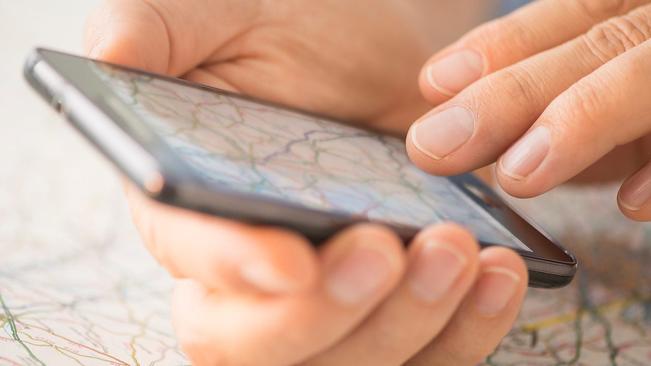 Close-up of hand using smartphone over map