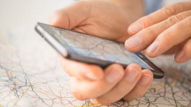 Close-up of hand using smartphone over map