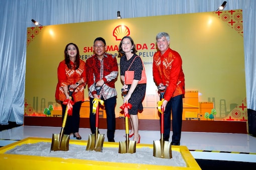 People posing for the photo with the shovel in the hand