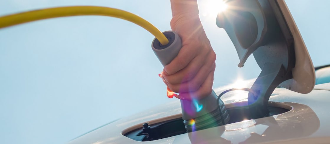 Person charging electric vehicle