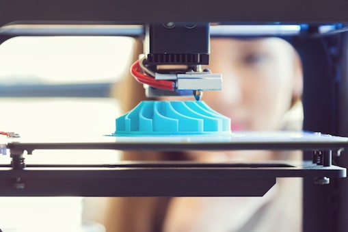 Woman watching 3D printout.