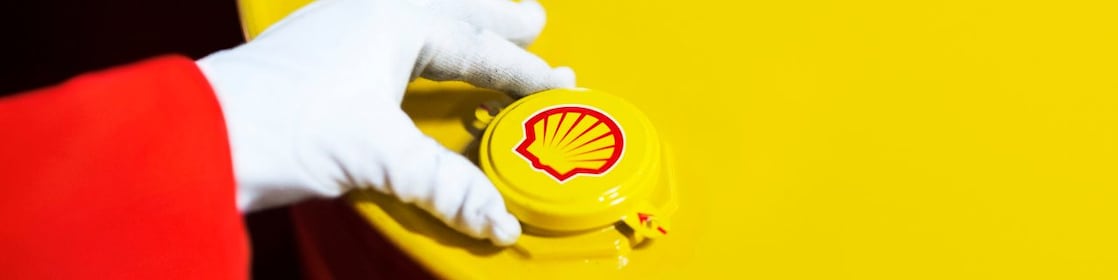 A Shell expert adjusts the lid of a barrel of lubricant displaying the Shell logo