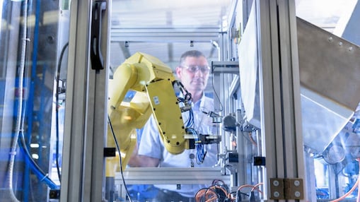 man looking at robotic machine