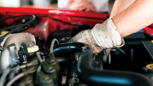 Mechanic wearing gloves fixing an engine