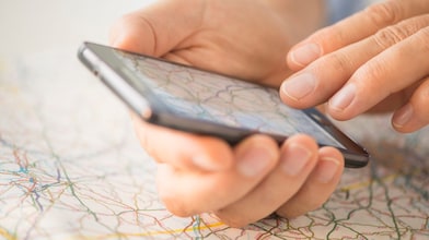 Close-up of hand using smartphone over map