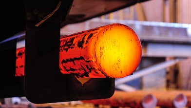 Steel worker mixing melted steel