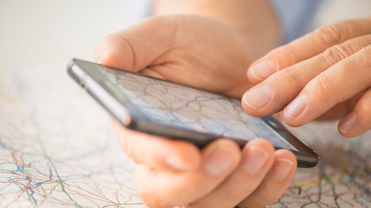 Close-up of hand using smartphone over map