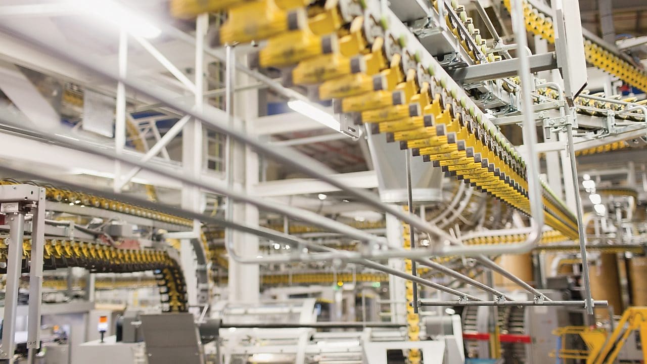 Automated conveyor system inside a modern industrial facility, used for material handling during the manufacturing process.