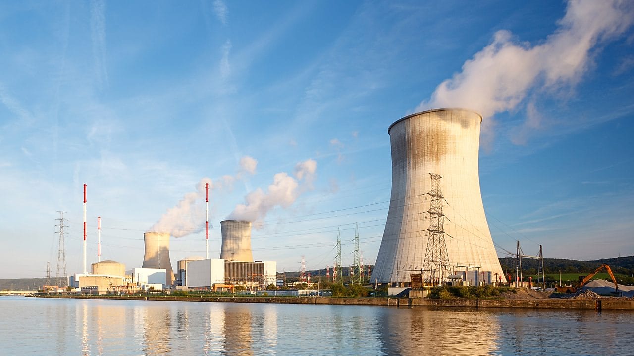 Cooling towers and chimneys of a power plant emitting steam.