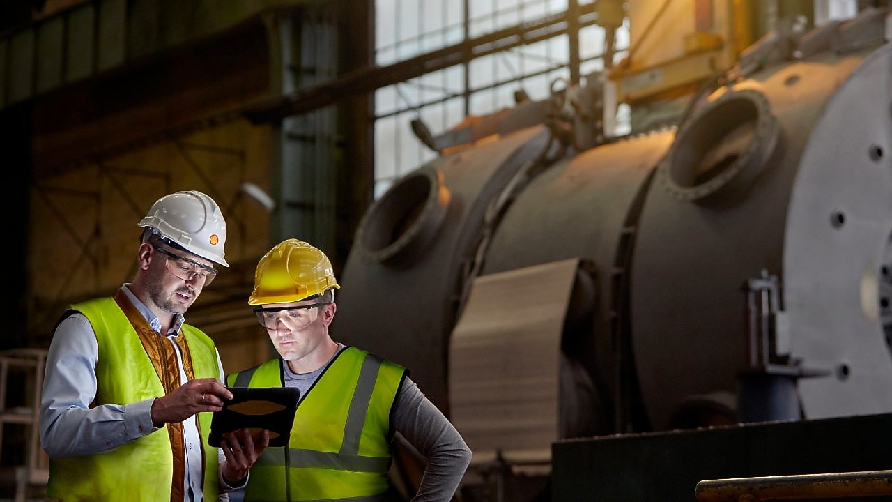 Shell worker consulting an industry worker on site
