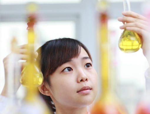 Scientist looking up at test tube