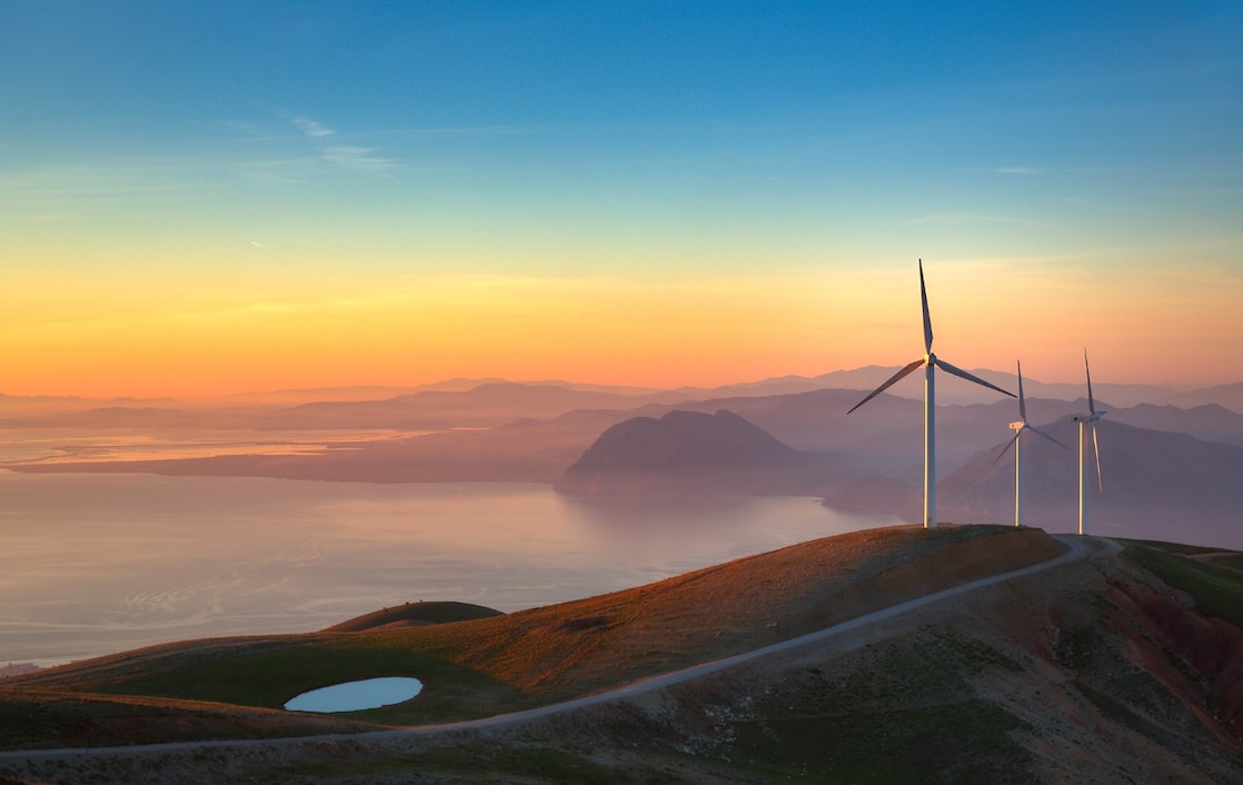 wind turbines overlook a stunning horizon