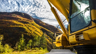 Yellow digger in mountainous background