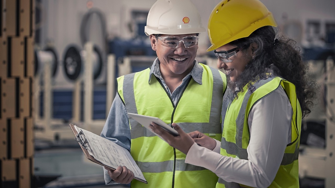 Two engineers looking at tablet in hard hats