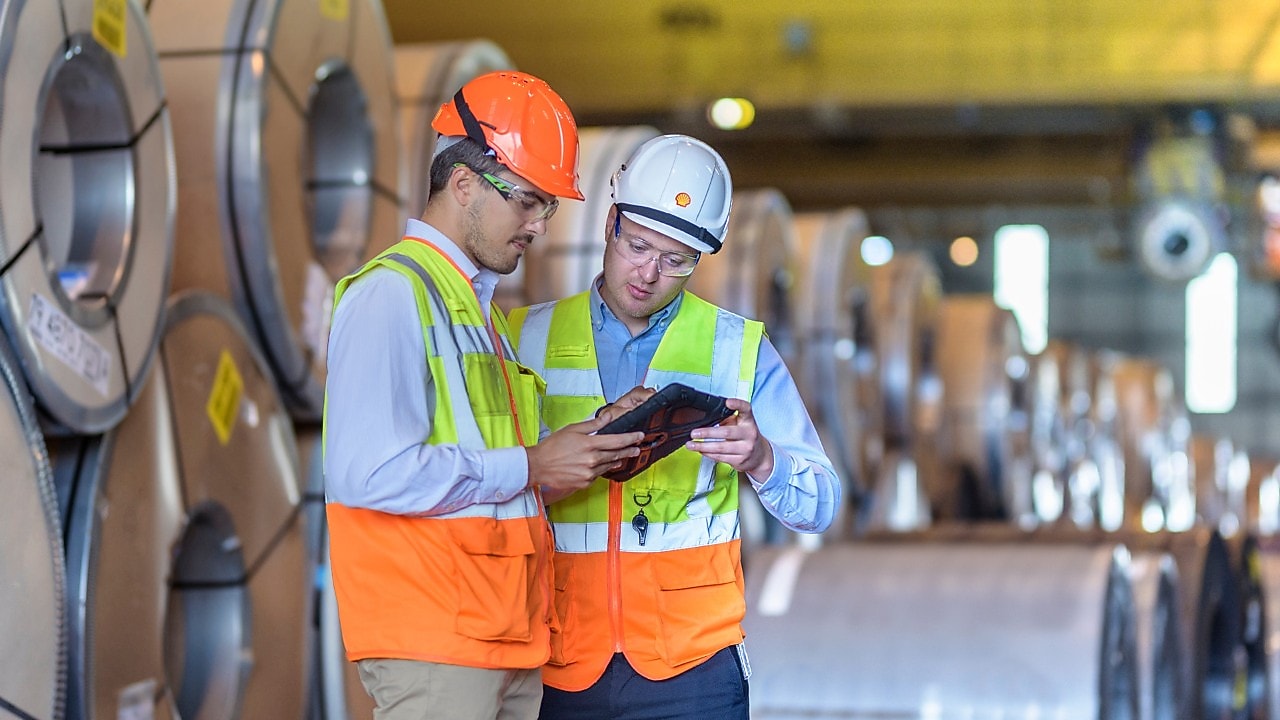 Two engineers looking at tablet in hard hats