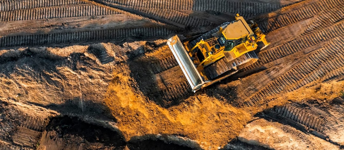Birdseye view of digger rolling on construction site