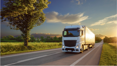 Truck driving across green fields