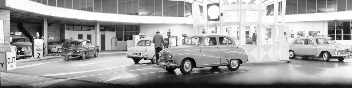 Motorists fueling cars at petrol pumps on the forecourt of Turnbull's in Plymouth in the U.K., August 1963.