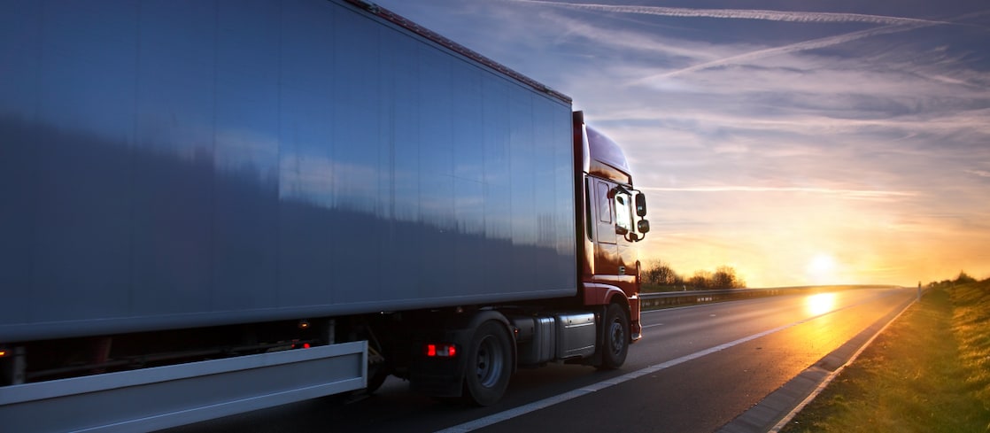 Heavy duty freight truck on a highway at sunrise