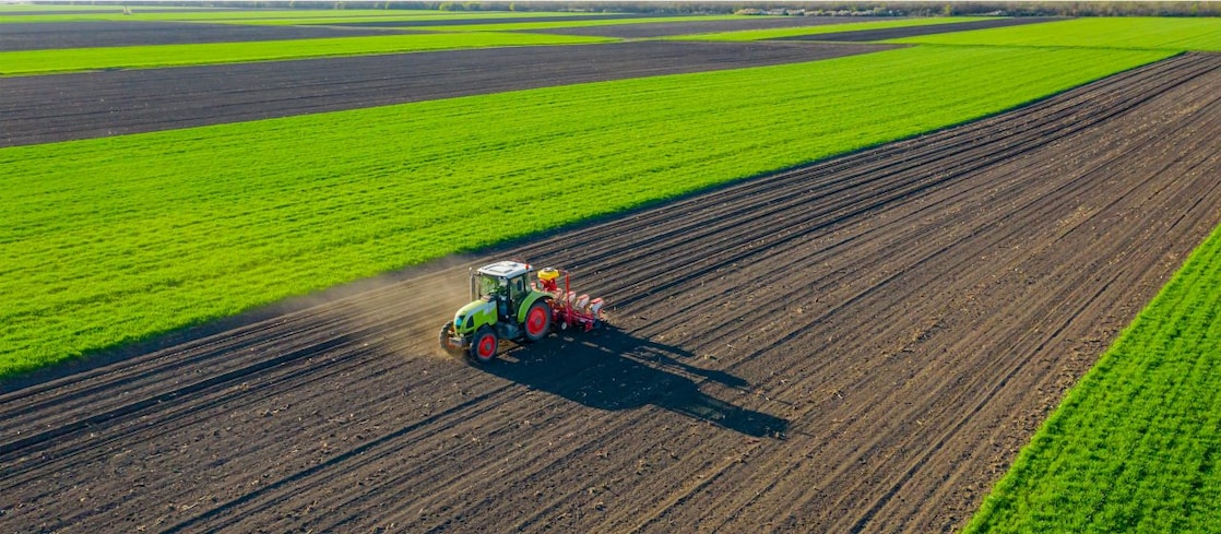 Green tractor working a field