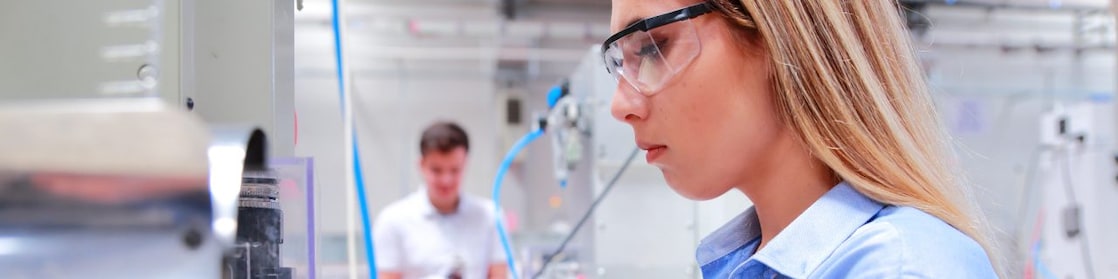 Female factory worker inspecting machinery