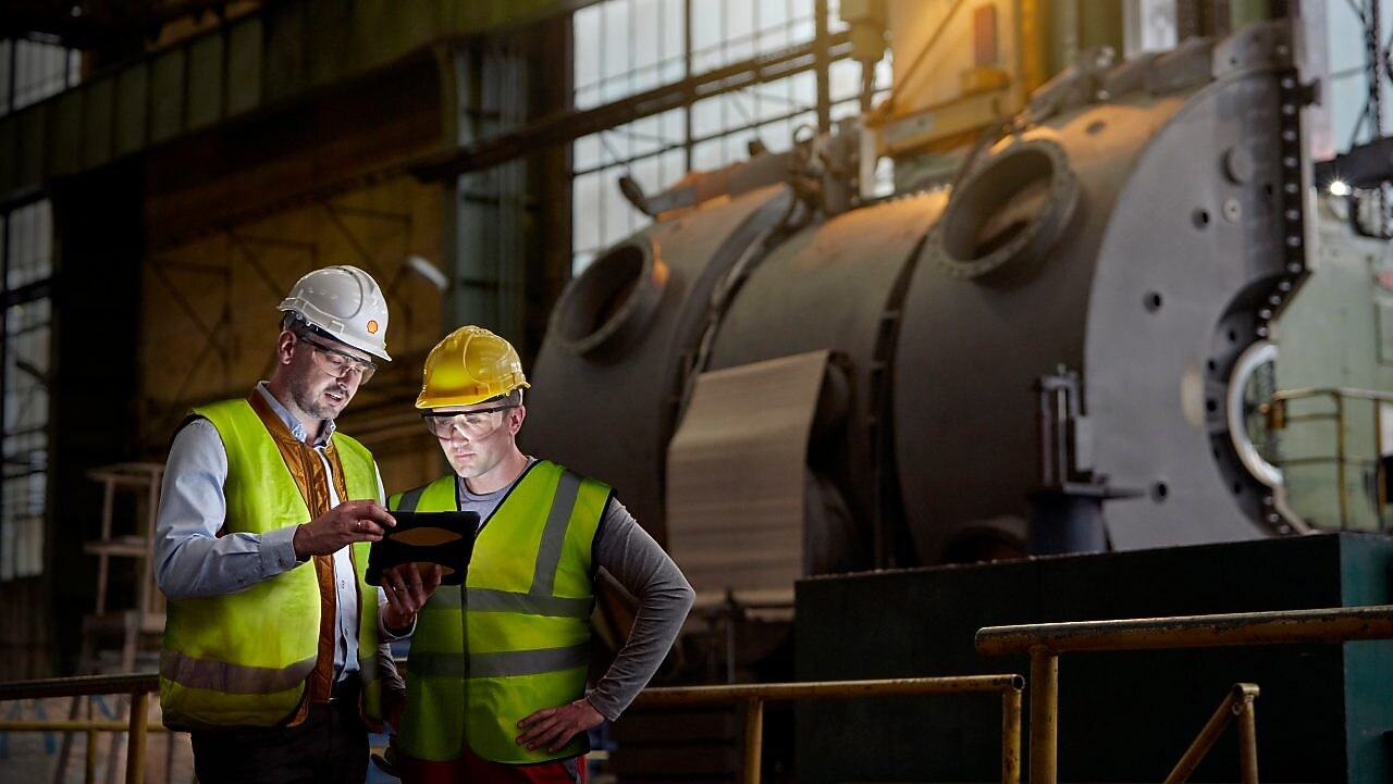 Shell worker consulting an industry worker on site